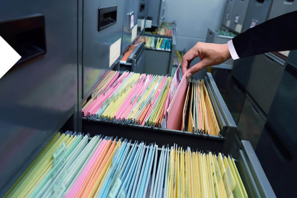 Hand pulling a file from a file cabinet