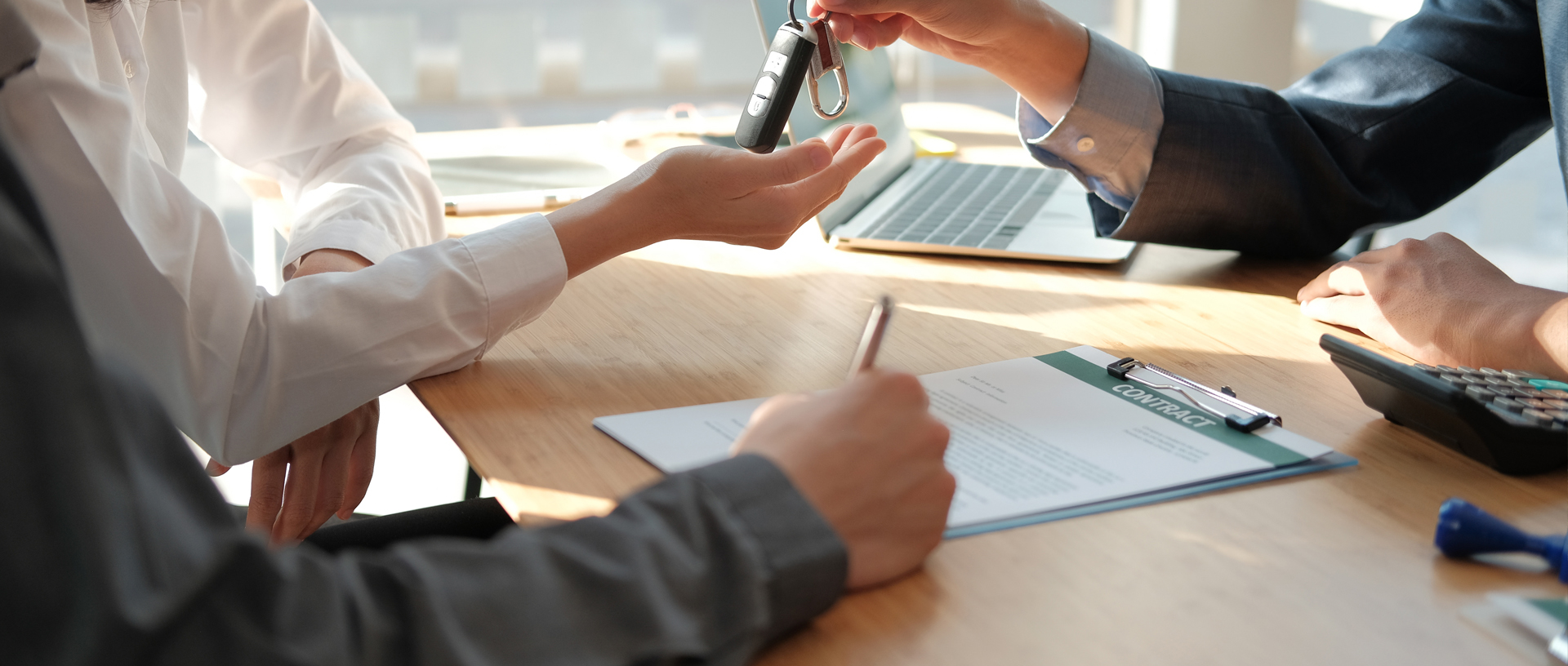 Couple signing new car sales contract and getting keys